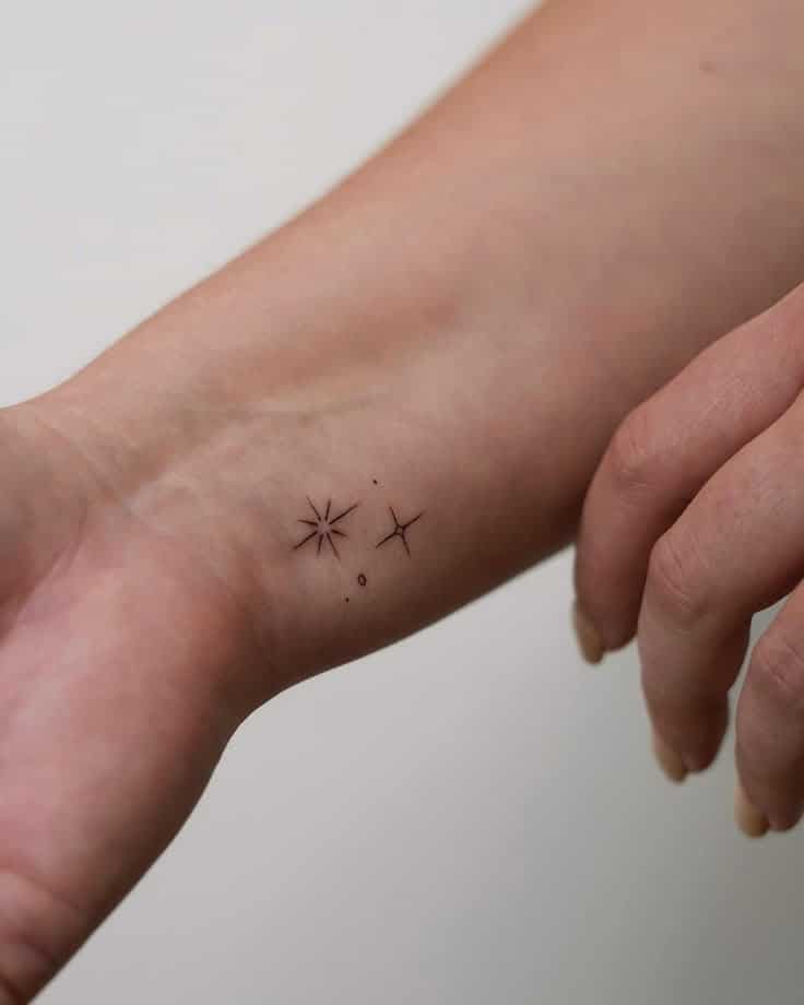 _ 1 Minimalist star tattoos on a wrist, showcasing delicate black ink designs on skin. | Sky Rye Design Minimalist star tattoos on a wrist, showcasing delicate black ink designs on skin.