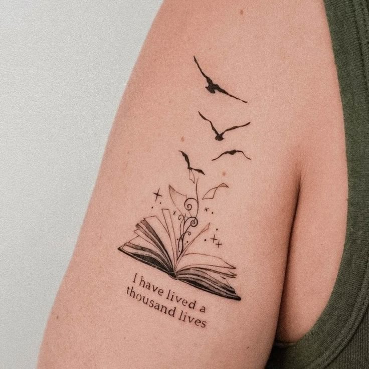 _ 1 Tattoo of an open book with birds and the quote I have lived a thousand lives on an arm. | Sky Rye Design Tattoo of an open book with birds and the quote I have lived a thousand lives on an arm.