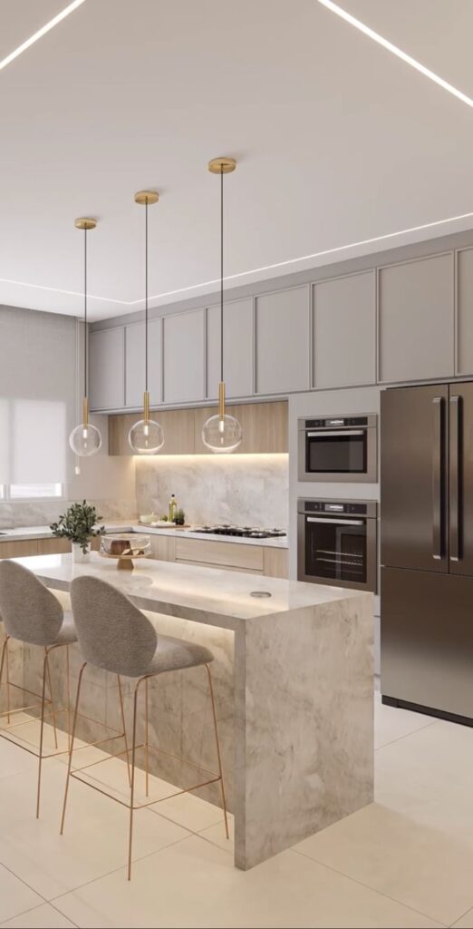 Screenshot Modern kitchen with marble island, pendant lights, and stainless steel appliances. Minimalist design and neutral tones. | Sky Rye Design Modern kitchen with marble island, pendant lights, and stainless steel appliances. Minimalist design and neutral tones.