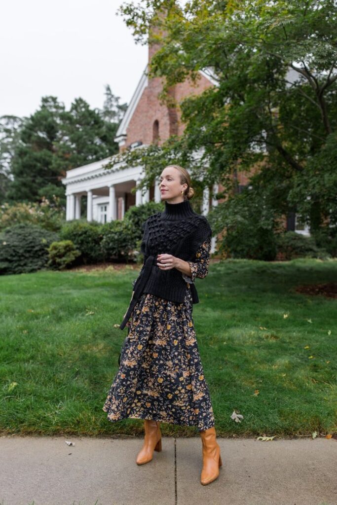 _ 10 Woman in floral dress and sweater vest outside a brick building, styled with tan boots on a grassy lawn. | Sky Rye Design Woman in floral dress and sweater vest outside a brick building, styled with tan boots on a grassy lawn.