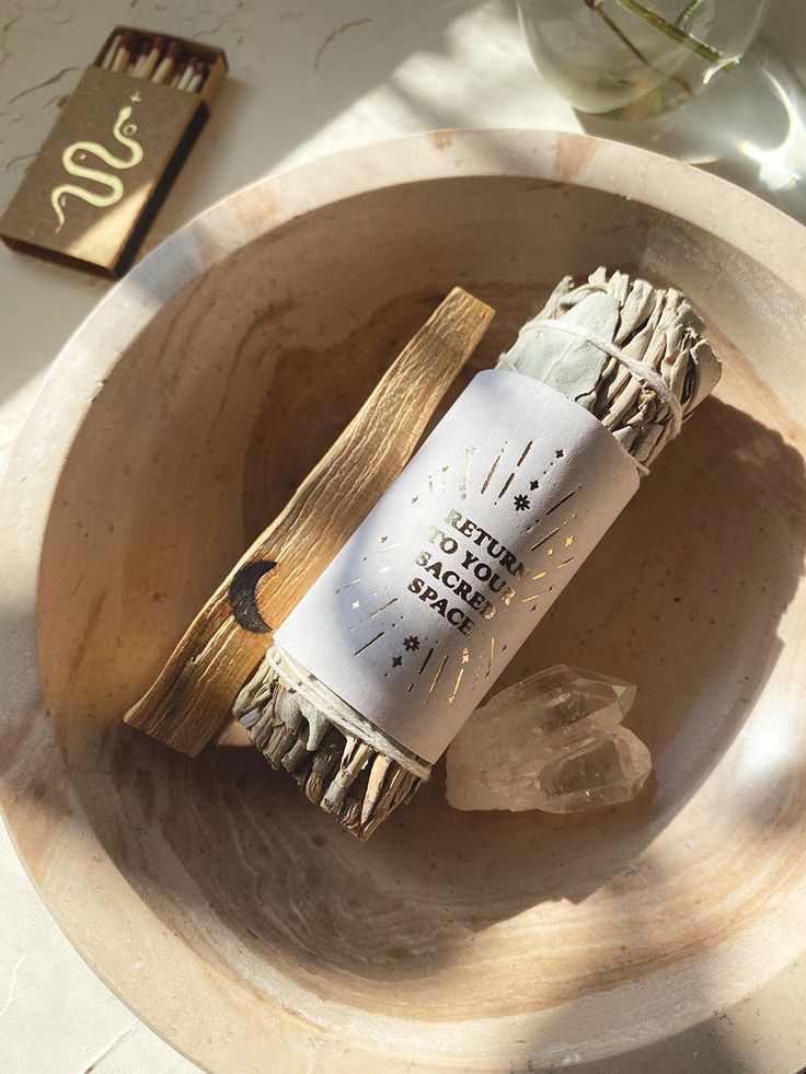 Incense bundle and crystals in a decorative bowl with sunlight, promoting relaxation and a sacred space atmosphere.