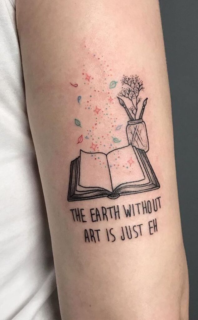 _ 11 Tattoo of an open book with art supplies, colorful accents, and the phrase The earth without art is just eh. | Sky Rye Design Tattoo of an open book with art supplies, colorful accents, and the phrase The earth without art is just eh.