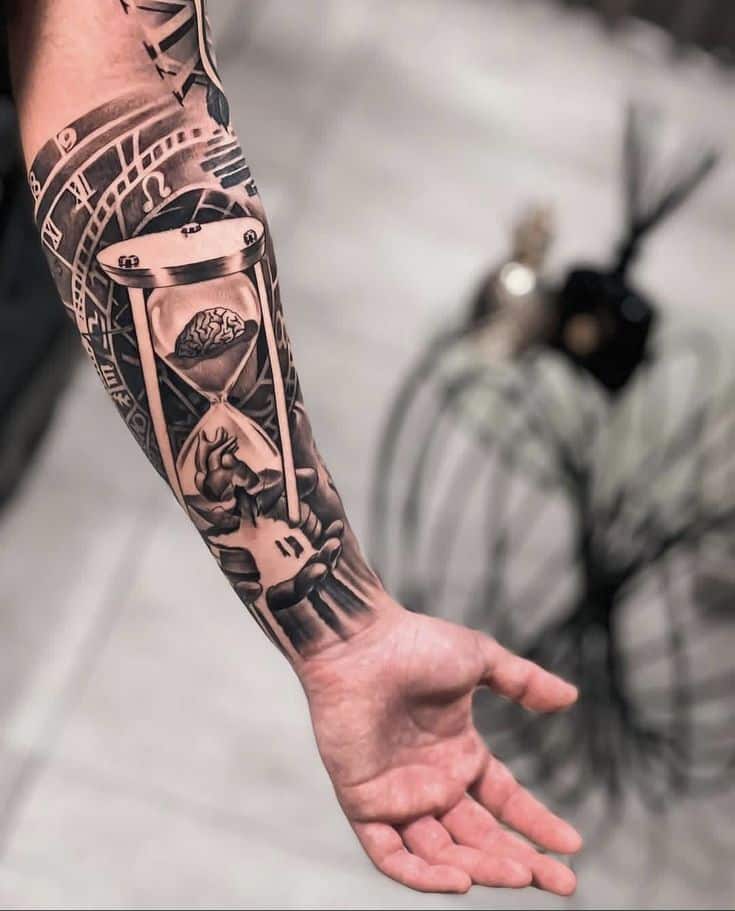 Forearm tattoo featuring an hourglass with a brain and heart, symbolizing time and emotions on a person’s arm.