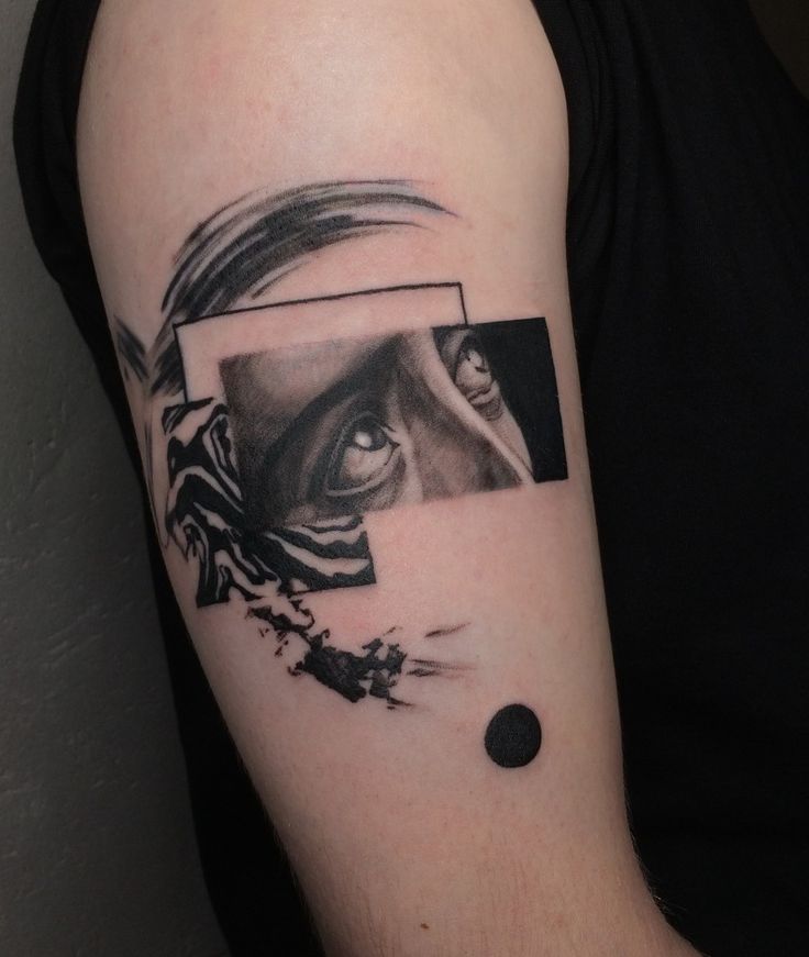 Abstract tattoo design featuring a realistic eye and geometric shapes on an arm.