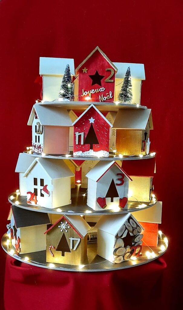 _ 12 Festive DIY Christmas Advent calendar with numbered red, white houses and lights on a red background. | Sky Rye Design Festive DIY Christmas Advent calendar with numbered red, white houses and lights on a red background.