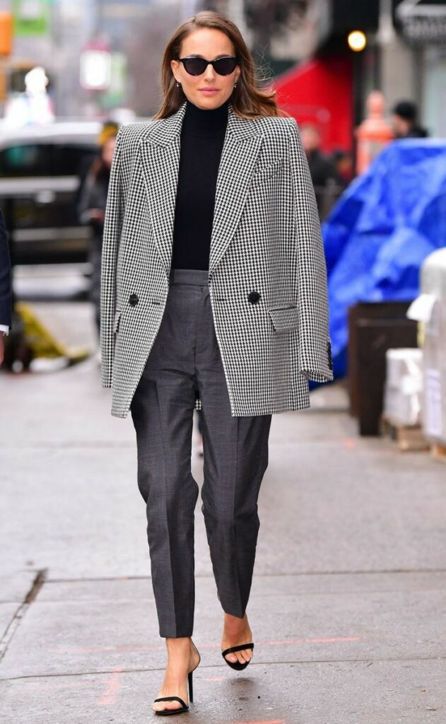 _ 13 Stylish woman in houndstooth blazer, black top, gray pants, and heels walking confidently on city street. | Sky Rye Design Stylish woman in houndstooth blazer, black top, gray pants, and heels walking confidently on city street.
