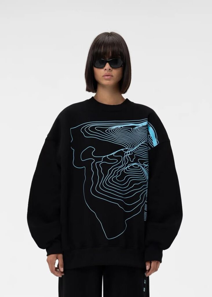 _ 13 Model wearing black sweatshirt with intricate neon blue line art design, paired with sunglasses. Minimalist fashion. | Sky Rye Design Model wearing black sweatshirt with intricate neon blue line art design, paired with sunglasses. Minimalist fashion.
