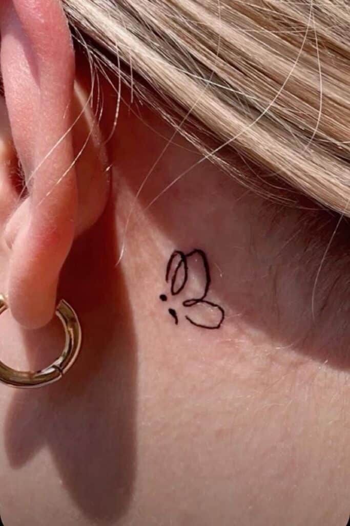 _ 13 Minimalist bunny tattoo behind ear with golden hoop earring and blonde hair detail. | Sky Rye Design Minimalist bunny tattoo behind ear with golden hoop earring and blonde hair detail.