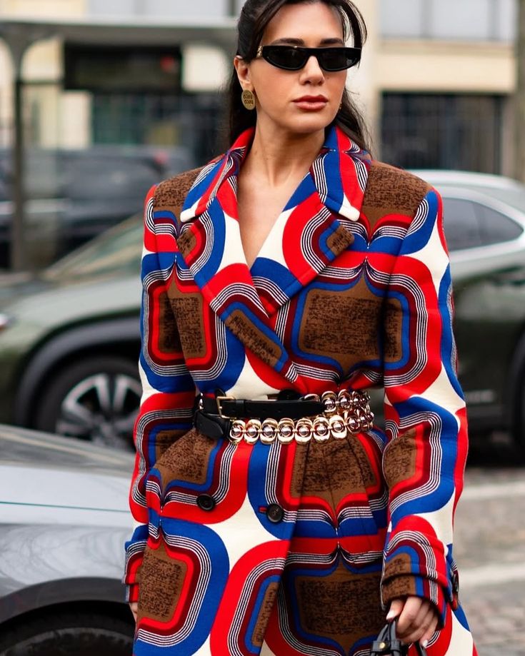 _ 14 Woman in a bold, geometric patterned coat with sunglasses, showcasing urban fashion style. | Sky Rye Design Woman in a bold, geometric patterned coat with sunglasses, showcasing urban fashion style.