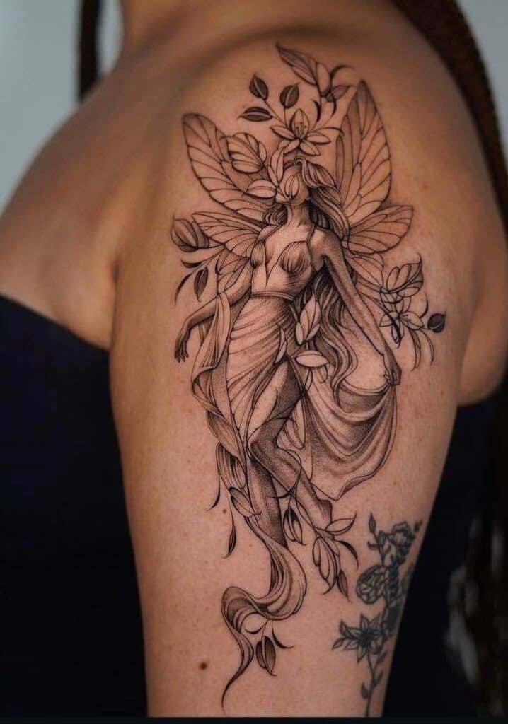 Elegant fairy tattoo with wings and leaves on a shoulder, featuring intricate details and flowing lines.