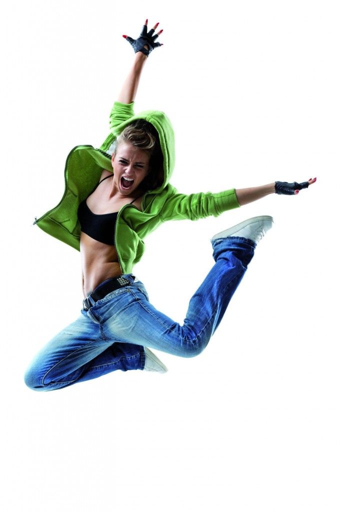 Person in green hoodie and jeans jumping energetically against a white background.