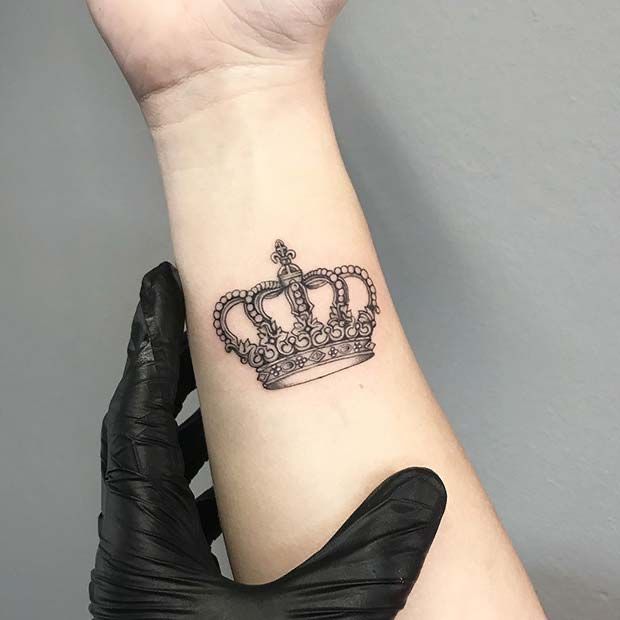 _ 15 Crown tattoo on forearm with detailed design, held by a hand in a black glove, showcasing elegant body art. | Sky Rye Design Crown tattoo on forearm with detailed design, held by a hand in a black glove, showcasing elegant body art.