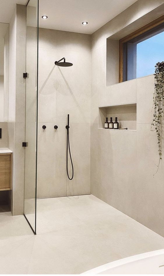 _ 15 Modern minimalist shower with glass door, beige tiles, and sleek black fixtures. | Sky Rye Design Modern minimalist shower with glass door, beige tiles, and sleek black fixtures.