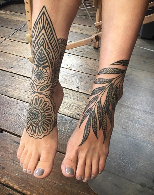 _ 15 Intricate floral and leaf tattoos on feet, resting on wooden floor. | Sky Rye Design Intricate floral and leaf tattoos on feet, resting on wooden floor.