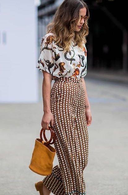 _ 16 Fashionable woman in printed outfit with a bucket bag, styled for a trendy streetwear look. | Sky Rye Design Fashionable woman in printed outfit with a bucket bag, styled for a trendy streetwear look.