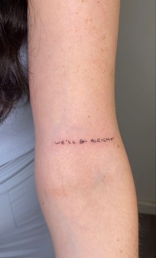 _ 16 Minimalist tattoo on inner arm with text We'll Be Alright, conveying positivity and resilience. | Sky Rye Design Minimalist tattoo on inner arm with text We'll Be Alright, conveying positivity and resilience.