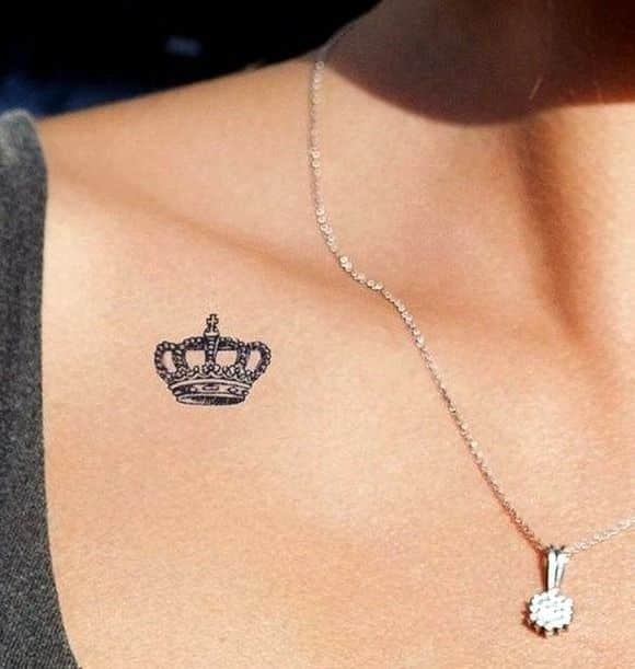 _ 17 Elegant crown tattoo on collarbone, paired with a delicate silver necklace pendant. Perfect minimalist style. | Sky Rye Design Elegant crown tattoo on collarbone, paired with a delicate silver necklace pendant. Perfect minimalist style.
