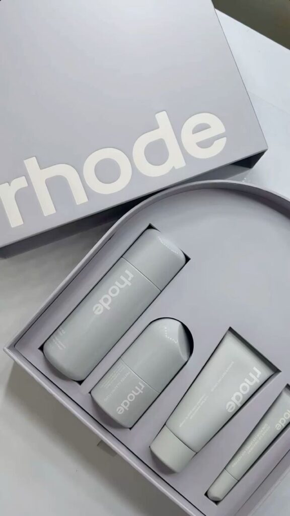 Skincare set in branded packaging with three sleek bottles arranged inside a box, showcasing elegant design.
