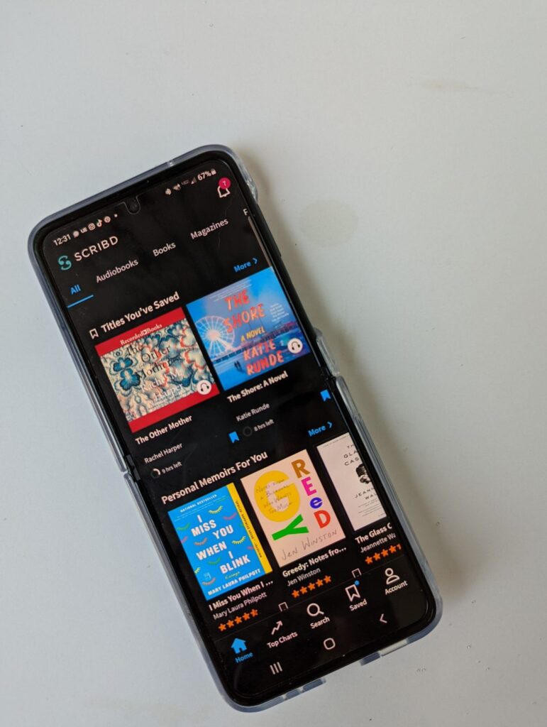17caca34a3d268ed022973ef1f258b17 Smartphone displaying Scribd app with book recommendations on screen. | Sky Rye Design Smartphone displaying Scribd app with book recommendations on screen.