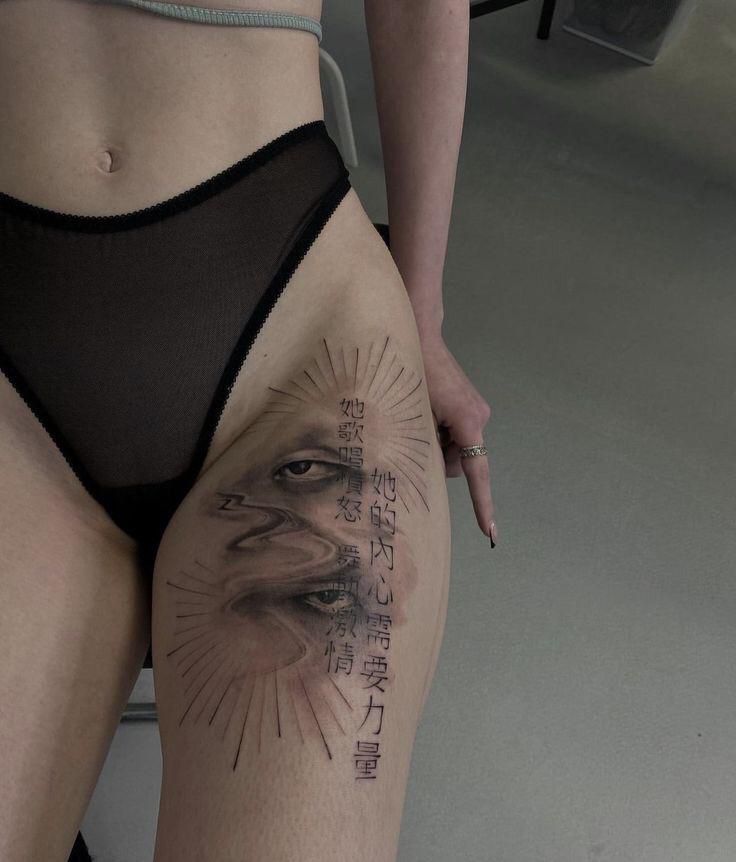 _ 18 Tattoo on woman's thigh featuring artistic eye design with Chinese characters, wearing black mesh underwear. | Sky Rye Design Tattoo on woman's thigh featuring artistic eye design with Chinese characters, wearing black mesh underwear.