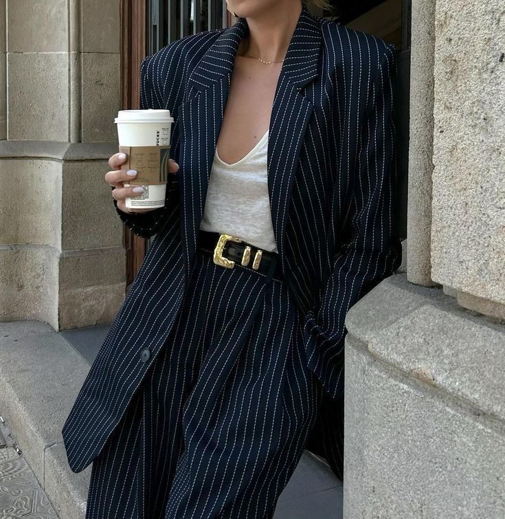 _ 18 Stylish woman in pinstripe suit holding coffee cup outside a building. Trendy fashion and urban lifestyle. | Sky Rye Design Stylish woman in pinstripe suit holding coffee cup outside a building. Trendy fashion and urban lifestyle.