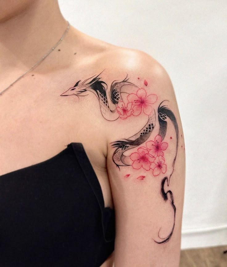 Elegant dragon tattoo with pink flowers on shoulder, combining intricate design and floral elements.