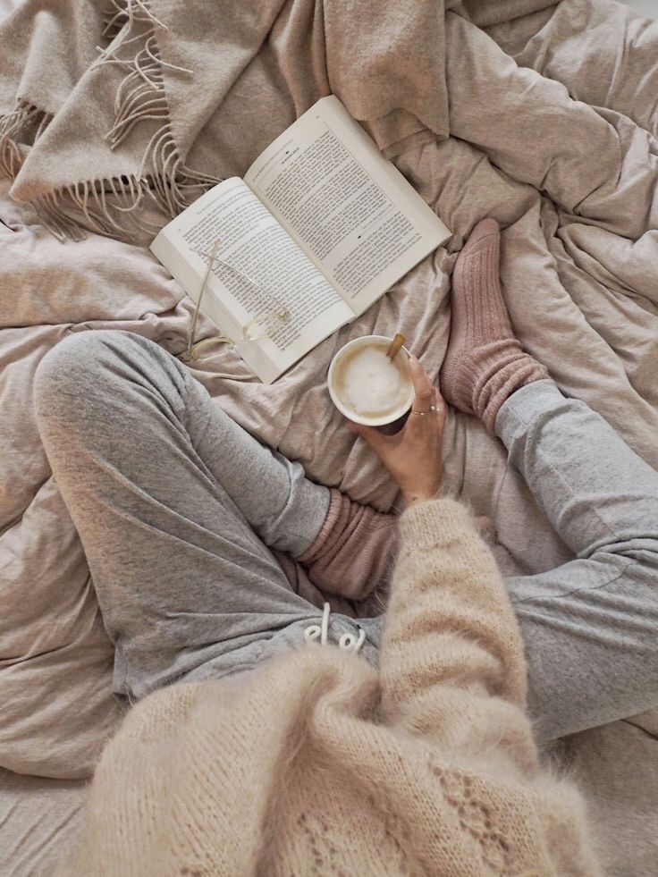 1ef46ed2-f6e5-44e8-968b-2e23d009ef97 Cozy setting: person in loungewear reading a book with hot drink, on a soft bed. Ideal cozy relaxation moment. | Sky Rye Design Cozy setting: person in loungewear reading a book with hot drink, on a soft bed. Ideal cozy relaxation moment.