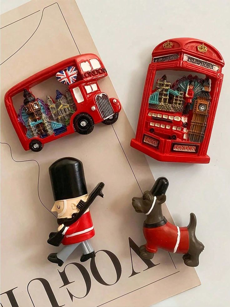 London-themed magnets: red bus, phone booth, royal guard, and dog on a magazine page.