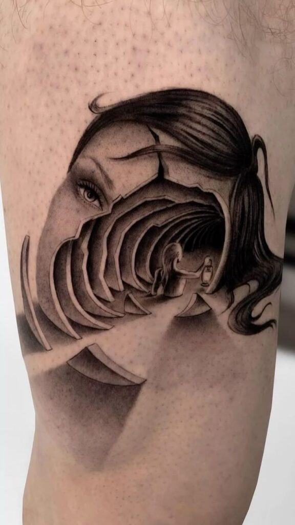 Surrealist tattoo design of a woman's face and tunnel illusion with intricate shading on skin.