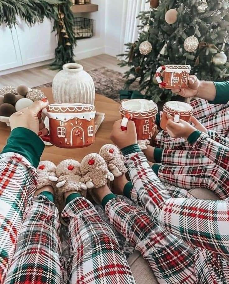 Family in matching festive pajamas with hot cocoa mugs, cozy by the Christmas tree, celebrating holiday cheer.