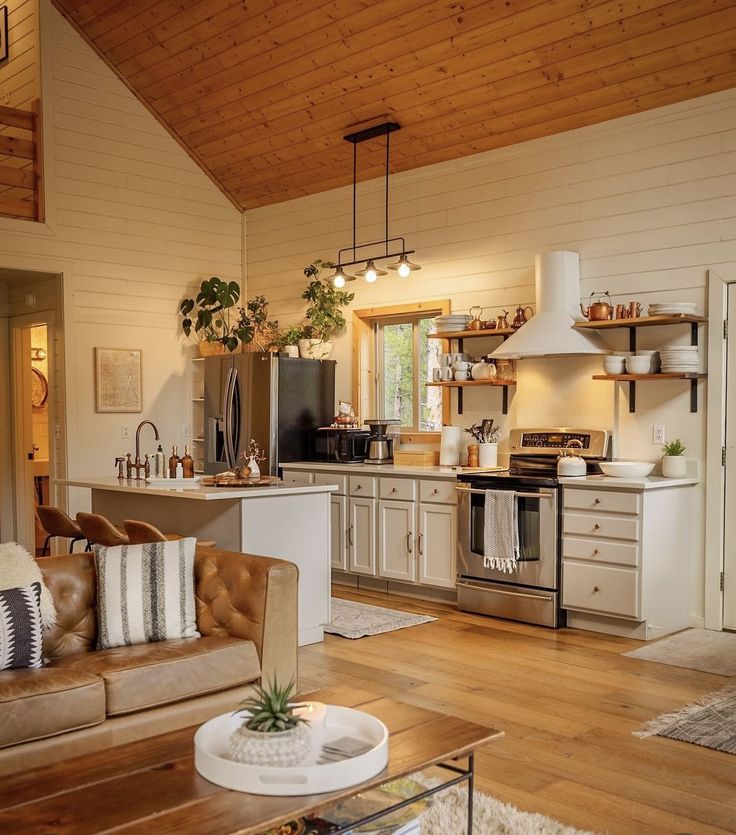 _ 2 Cozy modern kitchen with wooden ceiling, white cabinets, open shelving, and stainless steel appliances in rustic setting. | Sky Rye Design Cozy modern kitchen with wooden ceiling, white cabinets, open shelving, and stainless steel appliances in rustic setting.