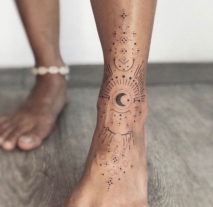 _ 2 Geometric ankle tattoo with celestial motifs, including moon and dots, on a wooden floor background. | Sky Rye Design Geometric ankle tattoo with celestial motifs, including moon and dots, on a wooden floor background.