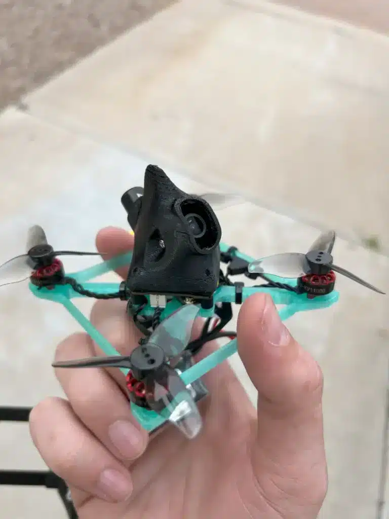 Person holding a small, lightweight drone with propellers and camera, designed for agile flight.