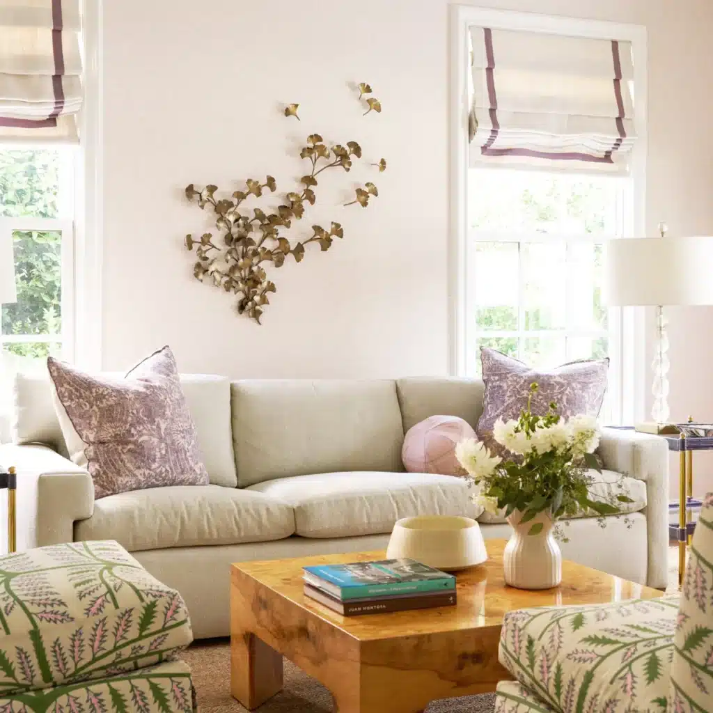 20248GingkoWall0369-edit Bright living room with a beige sofa, colorful pillows, floral decor, and a wooden coffee table under natural light. | Sky Rye Design Bright living room with a beige sofa, colorful pillows, floral decor, and a wooden coffee table under natural light.