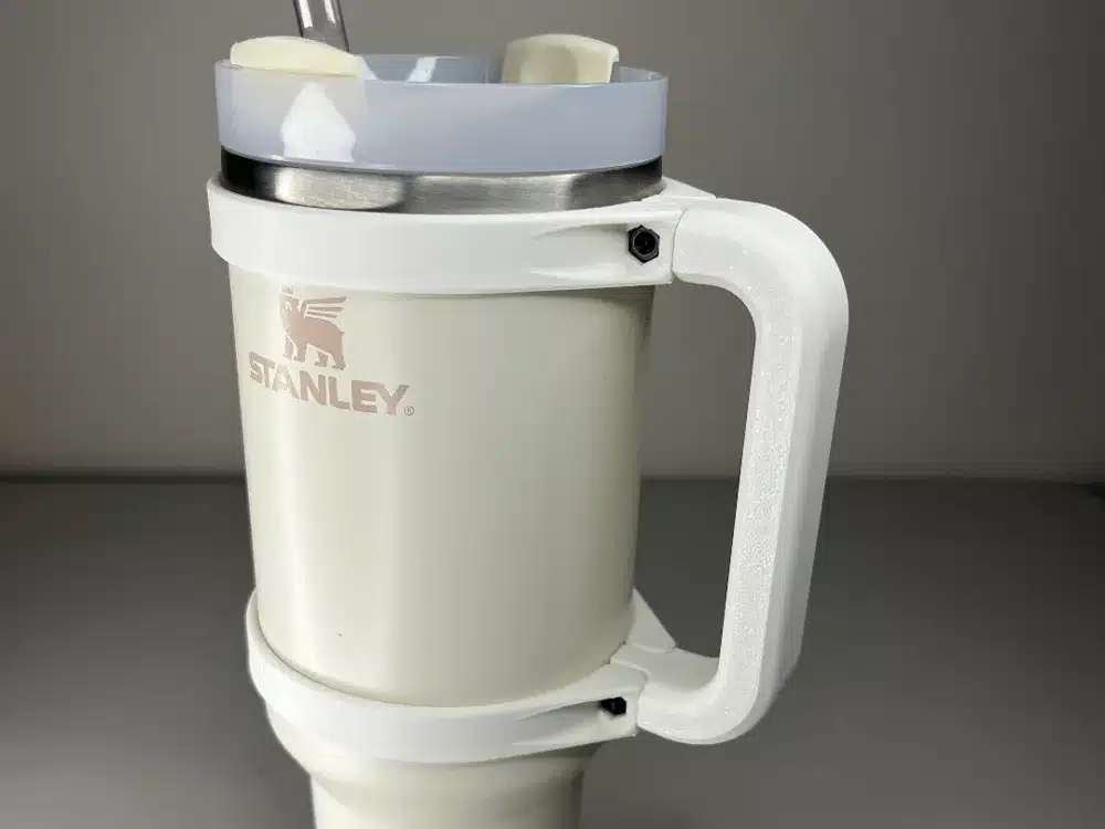 White Stanley insulated mug with handle and lid in close-up view on a neutral background.