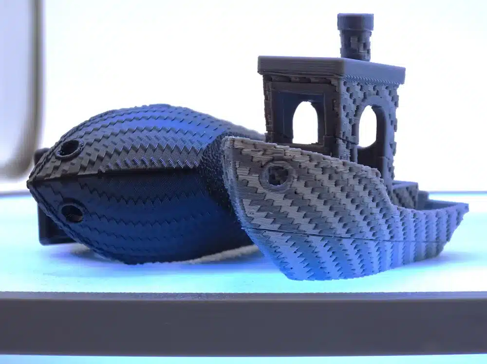 2025-04-15_ae826f63808ae8 3D printed boat in carbon fiber filament on a glowing surface, showcasing intricate texture and design. | Sky Rye Design 3D printed boat in carbon fiber filament on a glowing surface, showcasing intricate texture and design.