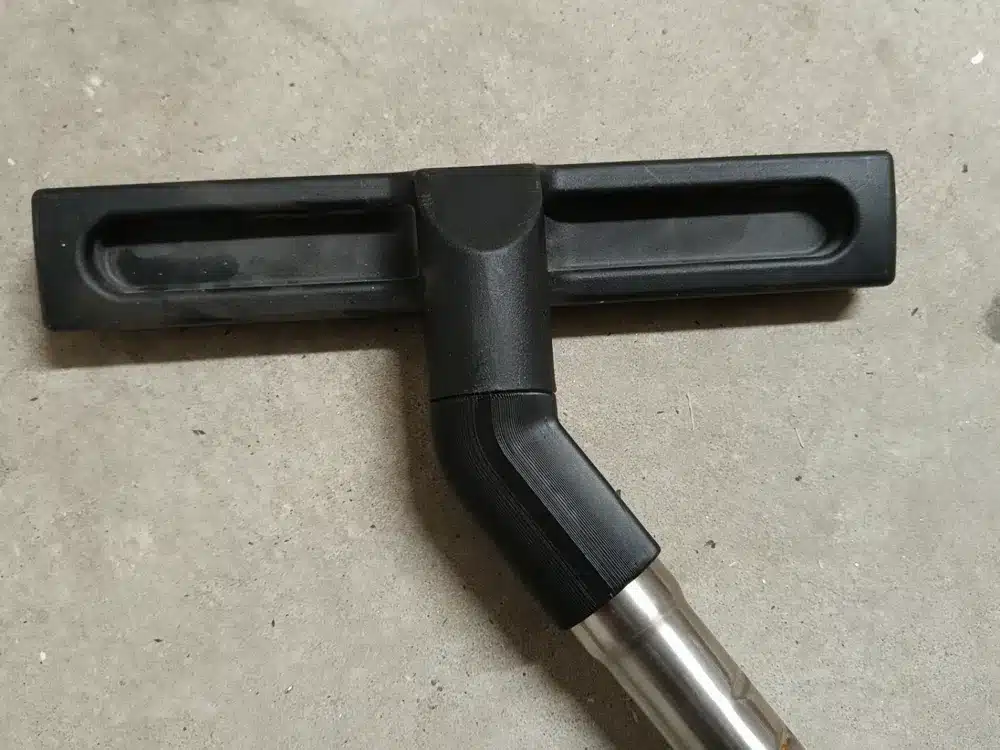 Vacuum cleaner floor attachment on concrete surface for efficient cleaning.