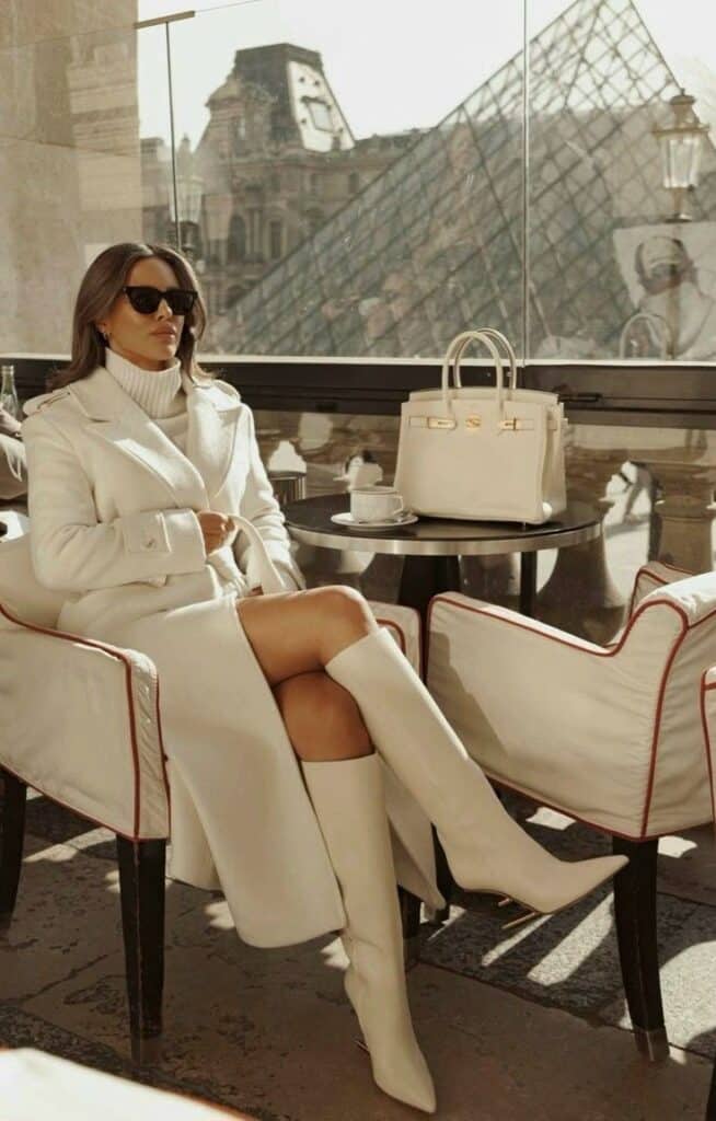 206c4a86-bb41-43e0-89e3-29266f1ee454 Elegant woman in white outfit sitting at café with view of Louvre Pyramid. Fashionable style and luxury handbag. | Sky Rye Design Elegant woman in white outfit sitting at café with view of Louvre Pyramid. Fashionable style and luxury handbag.