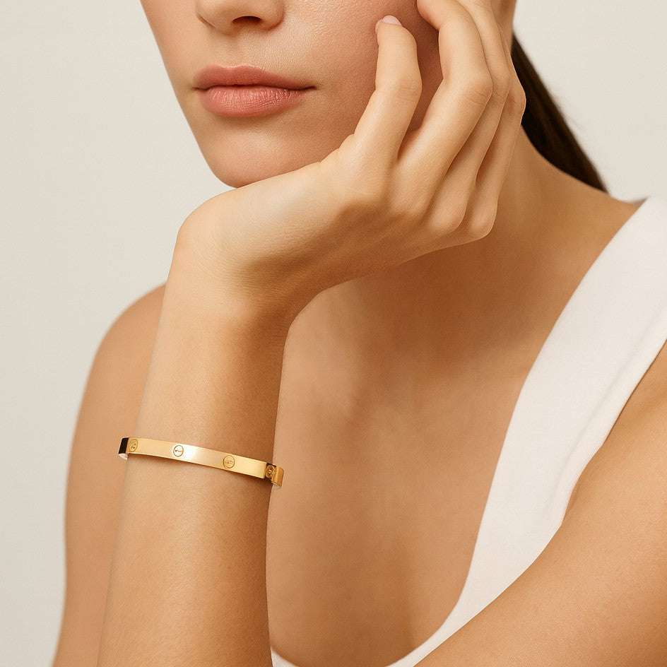 22050589-51159-pic Elegant gold bracelet on a woman's wrist, hand resting on chin, wearing a white top. | Sky Rye Design Elegant gold bracelet on a woman's wrist, hand resting on chin, wearing a white top.