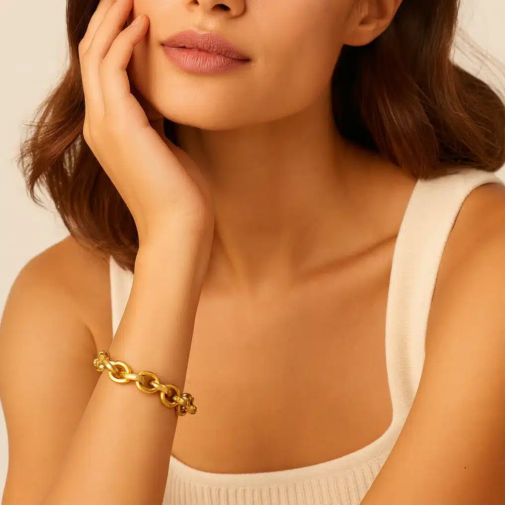 22061811-51177-pic Woman wearing a gold chain bracelet and a white top, resting her chin on her hand in a relaxed pose. | Sky Rye Design Woman wearing a gold chain bracelet and a white top, resting her chin on her hand in a relaxed pose.