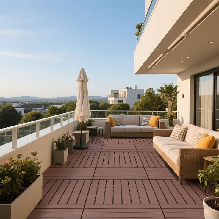 Modern rooftop terrace with comfy seating, plants, and views of a cityscape under a clear blue sky.