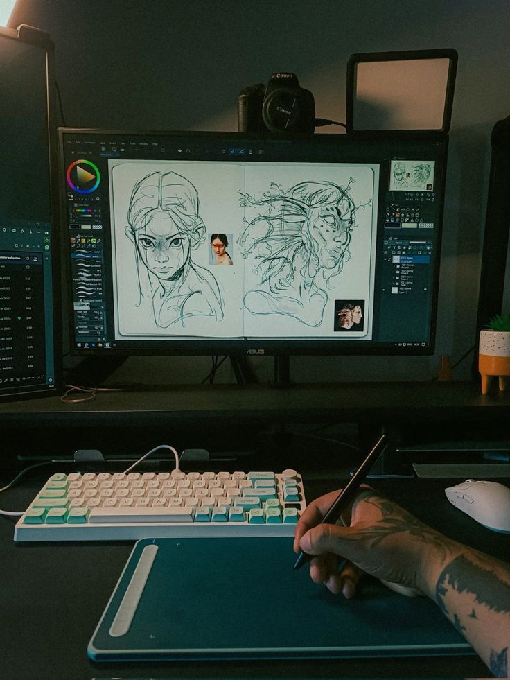 Digital artist using a tablet to sketch on a computer, with illustrations displayed on the screen.