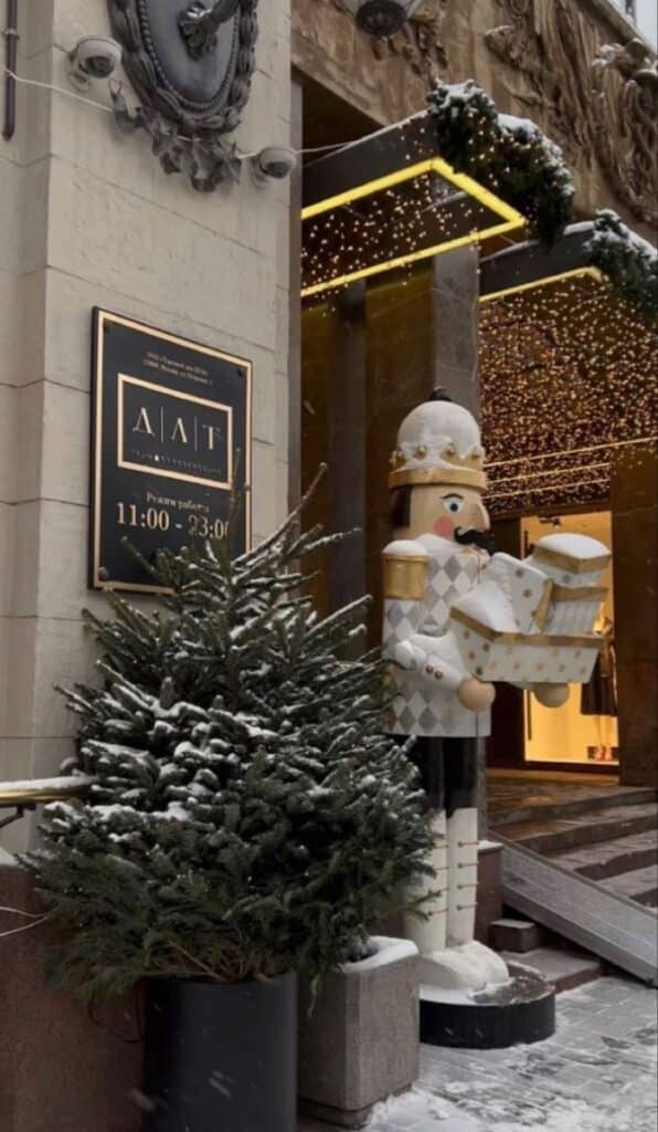 _ 25 Nutcracker statue and Christmas tree covered in snow by a shop entrance, decorated with festive lights. | Sky Rye Design Nutcracker statue and Christmas tree covered in snow by a shop entrance, decorated with festive lights. winter wallpaper