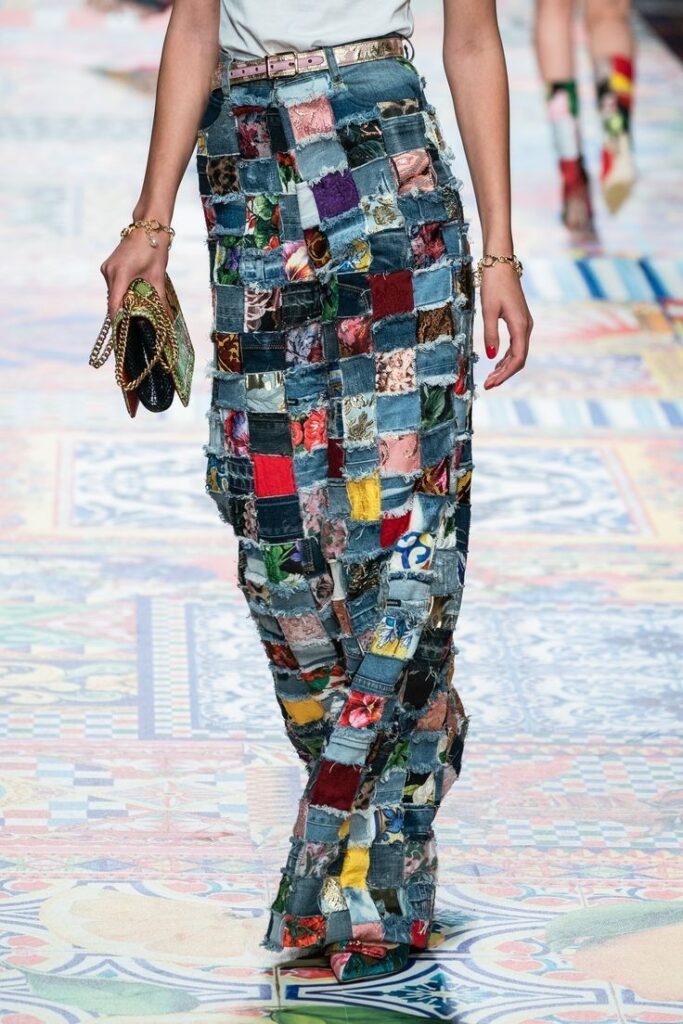 Fashion runway: Model wearing a colorful patchwork skirt paired with a stylish handbag and accessories.