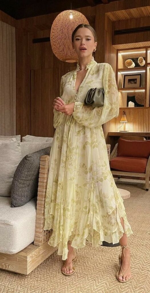 Woman in a floral dress in a stylish room with wooden accents and modern decor.