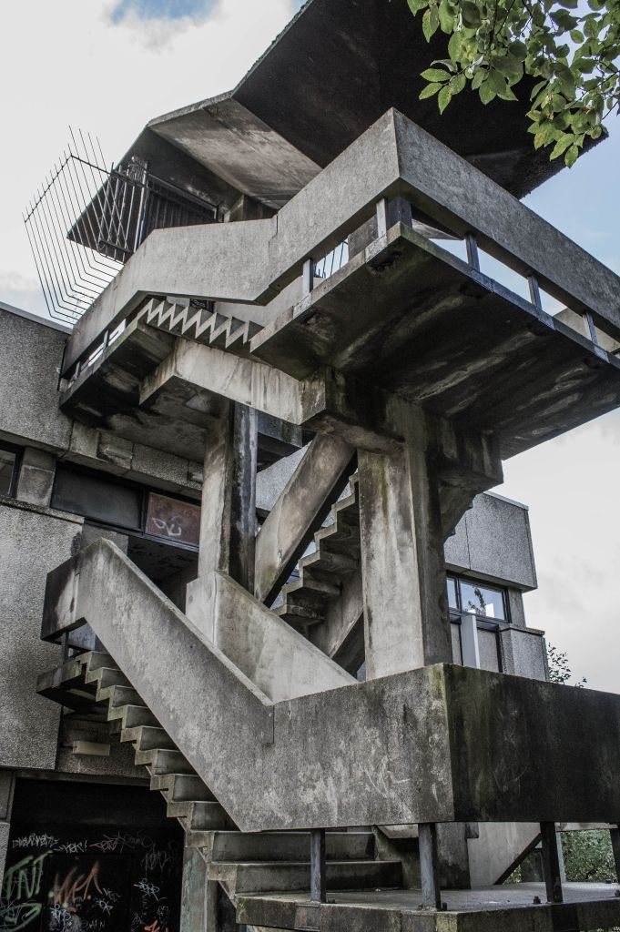 Brutalist architecture: concrete outdoor stairs in urban setting with angular design and overcast sky.