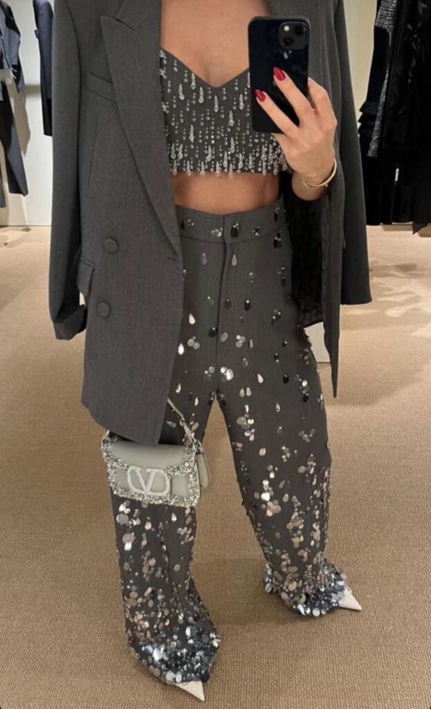 Stylish mirror selfie with a sequined two-piece set, grey blazer, and chic handbag. Glamorous fashion ensemble.