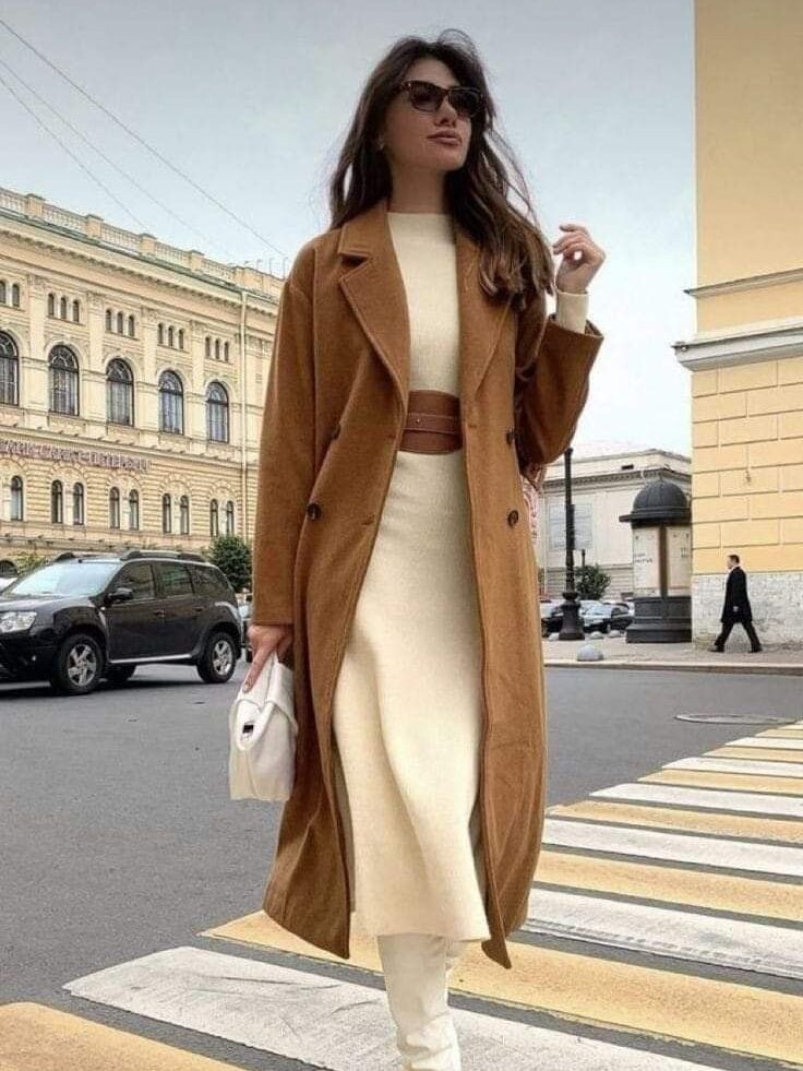 Woman in brown coat and white boots walking on city crosswalk, stylish fashion streetwear.