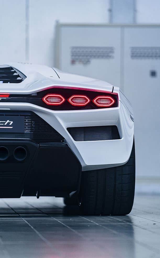 2e5bc6826966a5e5428cf0547d8cb5b1 Sleek rear view of a white sports car showcasing distinctive taillights and performance tires in a modern garage setting. | Sky Rye Design Sleek rear view of a white sports car showcasing distinctive taillights and performance tires in a modern garage setting.