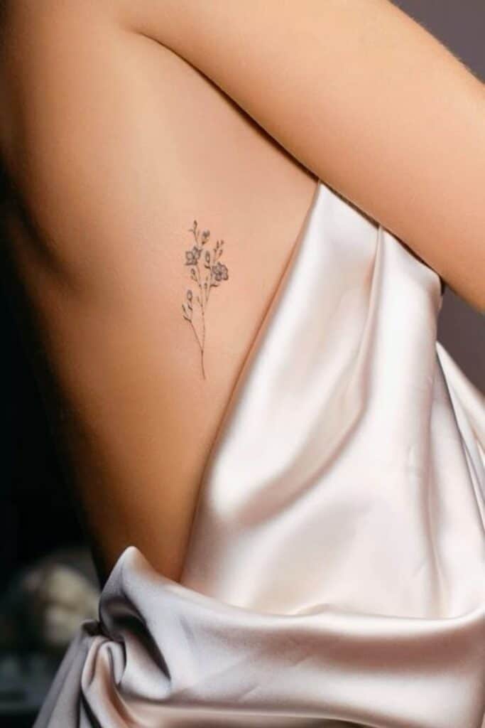 _ 3 Close-up of delicate floral tattoo on side, wrapped in soft satin fabric. Elegant minimalist body art. | Sky Rye Design Close-up of delicate floral tattoo on side, wrapped in soft satin fabric. Elegant minimalist body art.
